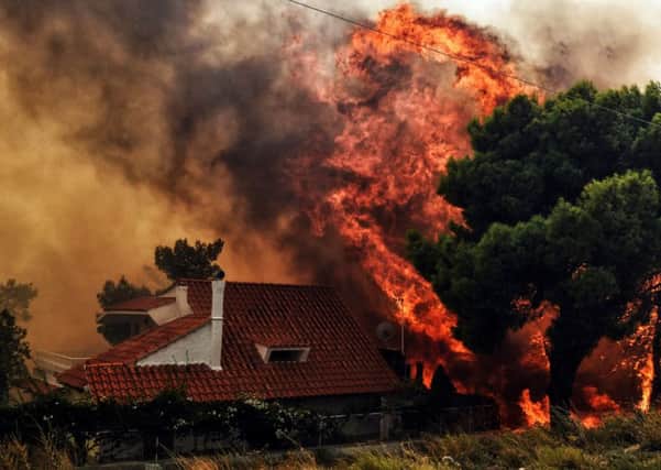 A sign of things to come: A wildfire threatens to engulf a house in Kineta near Athens last month (Picture: Valerie Gache/AFP/Getty)