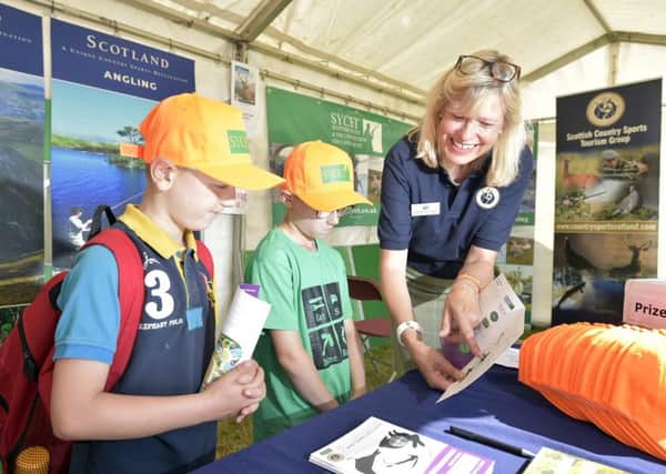 Youngsters taking part in the Junior Macnab have their game cards checked on the Scottish Country Sports Tourism Group stand at the GWCT Scottish Game Fair. Photo: Sandy Young