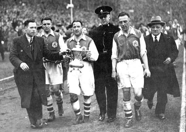 Alex James of Arsenal holds the FA Cup after the 1936 final