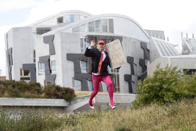 Roland Saunders takes a break from his Fringe show Fake TV to impersonate  Donald Trump outside the Scottish Parliament. Picture: Greg Macvean