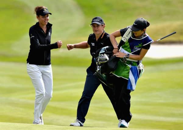 Michele Thomson, centre, and Meghan Maclaren fist bump after Thomson's great chip to the 18th and nerveless putt secured half a point for the British pair against Finland. Picture: Mark Runnacles/Getty Images