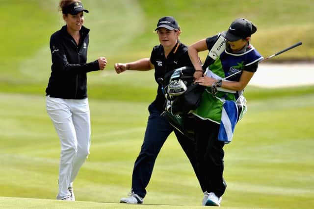 Michele Thomson, centre, and Meghan Maclaren fist bump after Thomson's great chip to the 18th and nerveless putt secured half a point for the British pair against Finland. Picture: Mark Runnacles/Getty Images
