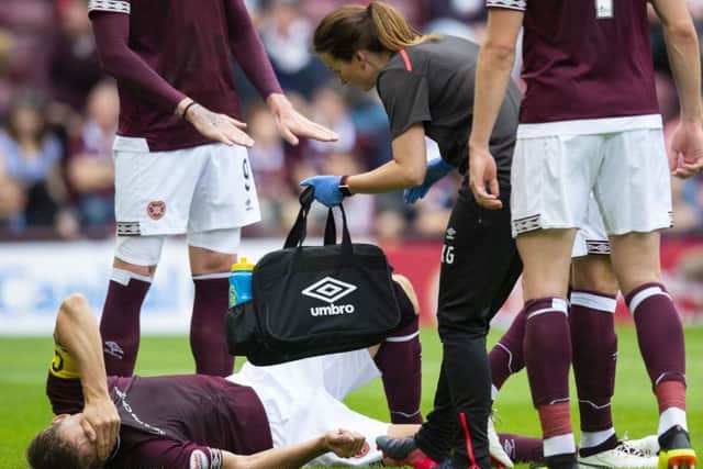 Hearts' Christophe Berra goes down injured against Celtic. Pic: SNS/Ross Parker