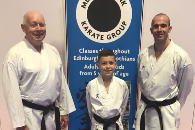 Bailey (9) is the latest member of the Adams family to hold a black belt in karate and is pictured alongside proud dad Steven and grandfather Hamish