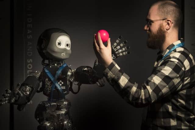 Phd student Eli Sheppard from Heriot Watt Edinburgh Centre for Robotoics plays with Nikita, a childlike humanoid robot that has been in development for more than 10 years.