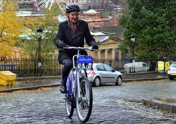 Scotsman transport correspondent Alastair Dalton tries out one of the electric bicycles that will be able for hire in Edinburgh from next year. Picture: Jon Savage