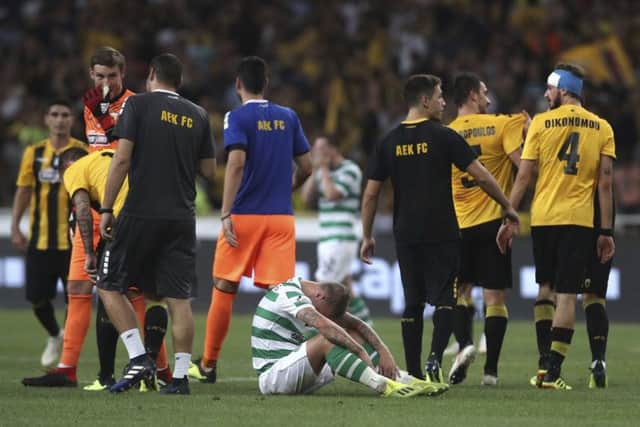 /Celtic's Leigh Griffiths, center, sits on the pitch after his team lost a Champions League third qualifying round, second leg, soccer match between AEK Athens and Celtic at the Olympic stadium in Athens, Tuesday, Aug. 14, 2018. (AP Photo/Petros Giannakouris)