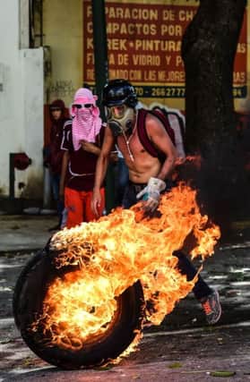 Protesters burn a tyre during a rally against President Nicolas Maduros government in the Venezuelan capital Caracas. AFP/Getty