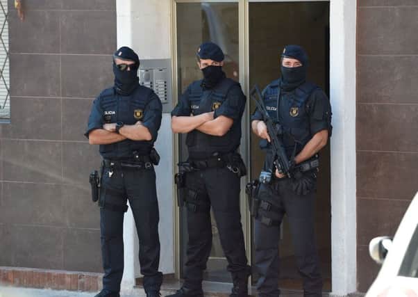 Catalan regional police forces stand guard outside the apartment building of a man who tried to attack a police station. Picture: AFP/Getty