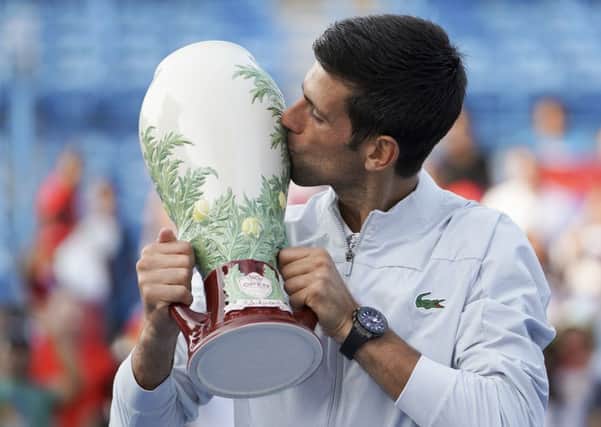 Novak Djokovic plants a big kiss on the Rookwood pottery trophy after his victory over Roger Federer in Cincinnati on Sunday. Picture: AP.