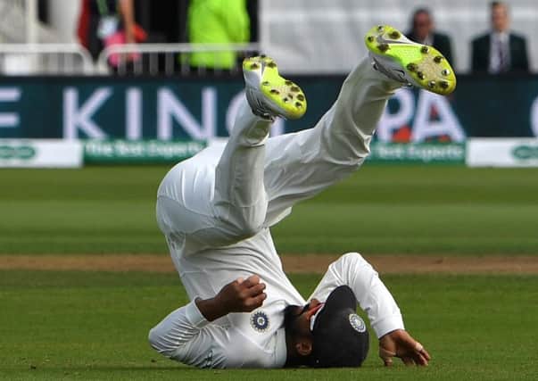 India's Ajinkya Rahane tumbles backwards after catching James Anderson in the slips. Picture: Paul Ellis/AFP/Getty