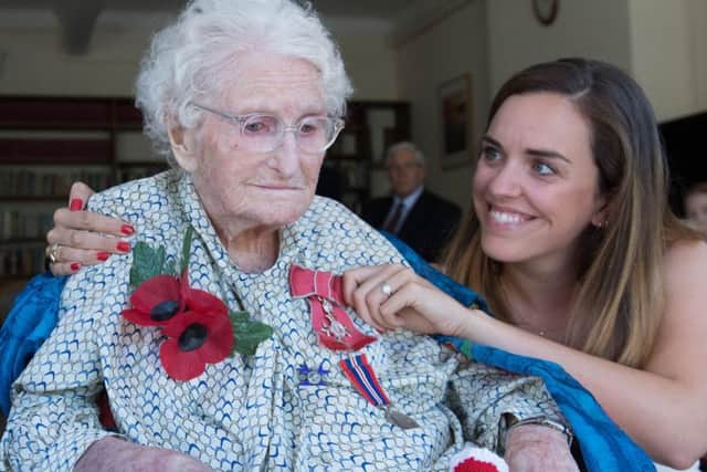 Rosemary Powell with her grand daughter, Celia Speller, receiving her MBE.