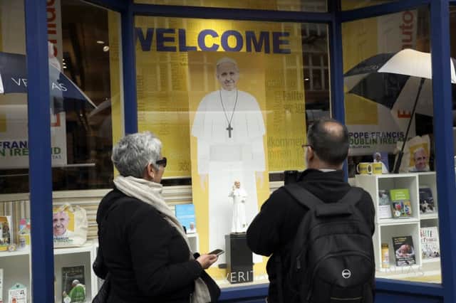 People look at a Pope Francis visit display in the front window of the Veritas religious bookshop in Dublin, Ireland. Picture: AP Photo/Matt Dunham.