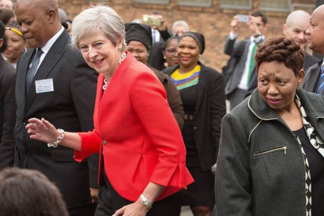 Theresa May dances with children in South Africa after reassuring the public that Brexit does not risk the end of the world (Picture: Rodger BoschAFP/Getty Images)