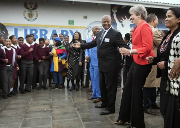 Theresa May dances with children during a visit to a school in Cape Town (Picture: AP)