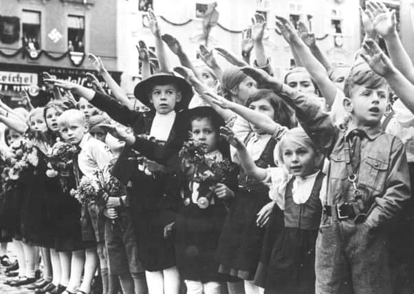 Children give the Nazi salute as Hitlers forces take over the Sudetenland in 1938 (Picture: Topical Press Agency/Getty Images)