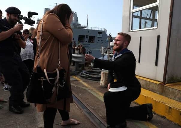 Joshua Bertman proposes to Hazel Staunton on the dock after he arrived back from deployment with the Royal Navy. Picture: Andrew Milligan/PA.