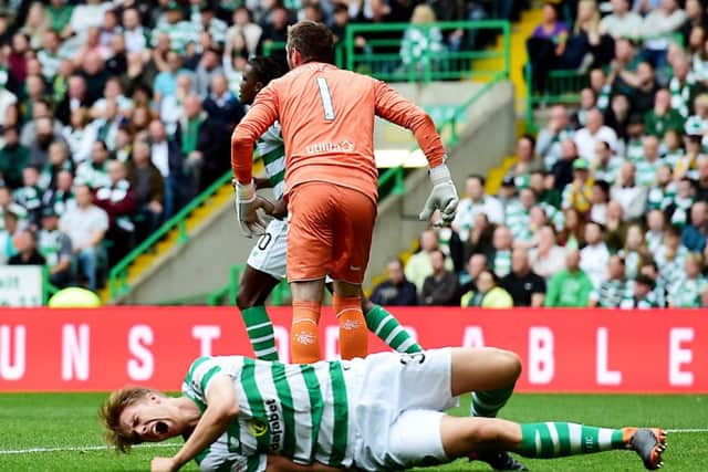 Celtic's Kristoffer Ajer lies on the ground after clashing with Rangers goalkeeper Allan McGregor. Picture: SNS