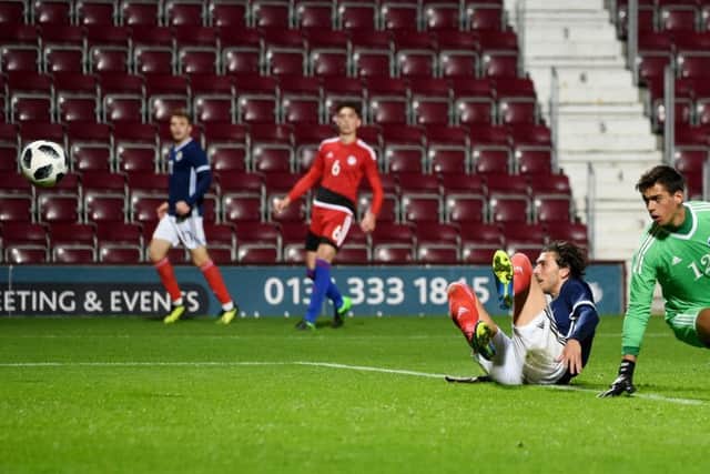 Fraser Hornby, grounded, watches his shot head towards the Andorra net as he completes his hat-trick in Scotlands 3-0 victory. Picture: SNS.