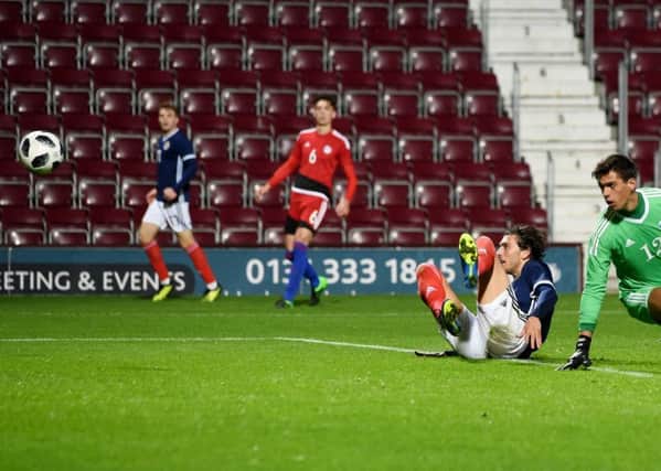 Fraser Hornby, grounded, watches his shot head towards the Andorra net as he completes his hat-trick in Scotlands 3-0 victory. Picture: SNS.