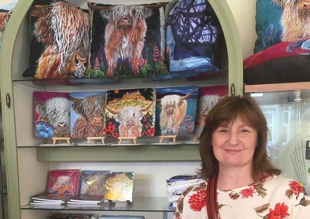 Heather McLennan with some of her Highland cow-based art