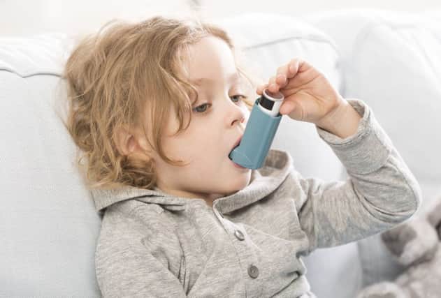 Small child using his inhaler device for asthma
