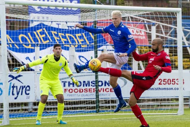Ross County's Liam Fontaine competes with Lyndon Dykes. Pic: SNS/Sammy Turner