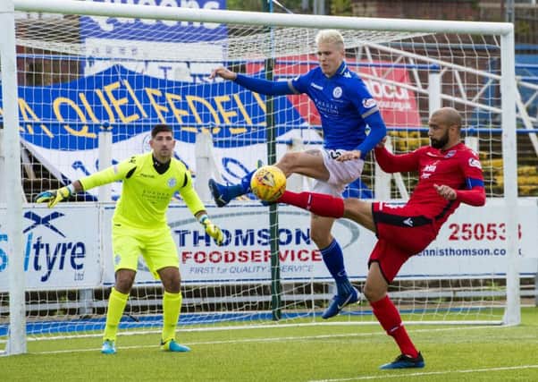 Ross County's Liam Fontaine competes with Lyndon Dykes. Pic: SNS/Sammy Turner