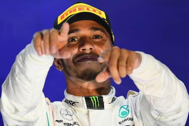 Lewis Hamilton celebrates on the podium after cruising to victory in the Singapore Grand Prix at Marina Bay Street Circuit. Picture: Clive Mason/Getty Images