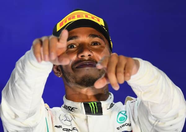 Lewis Hamilton celebrates on the podium after cruising to victory in the Singapore Grand Prix at Marina Bay Street Circuit. Picture: Clive Mason/Getty Images
