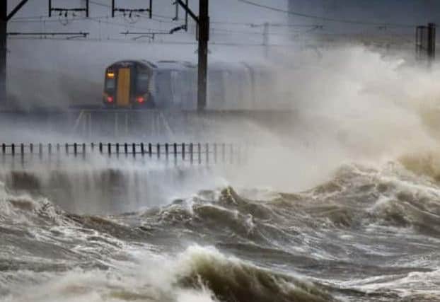 Waves batter a ScotRail train near Saltcoats. Picture: Press Association