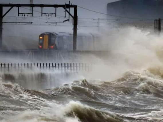 Waves batter a ScotRail train near Saltcoats. Picture: Press Association