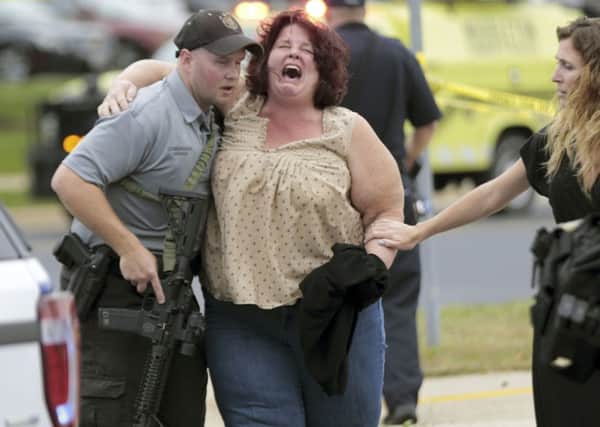 A woman is escorted from the scene of the shooting at a software company in Middleton, Wis. Picture: Steve Apps/Wisconsin State Journal via AP