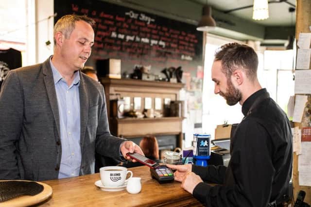 Colin Munro, founder of Miconex, the firm behind the loyalty scheme, tests out the technology in a Perth cafe.