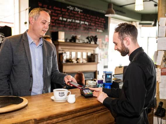 Colin Munro, founder of Miconex, the firm behind the loyalty scheme, tests out the technology in a Perth cafe.