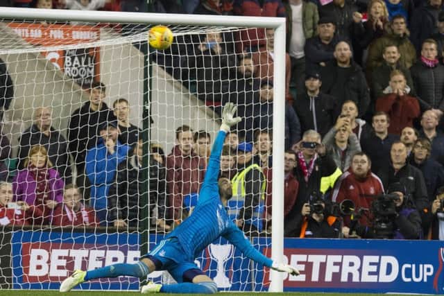 Joe Lewis dives as Thomas Agyepong (not pictured) hits the crossbar with his penalty to hand Aberdeen victory in the shootout. Picture: SNS
