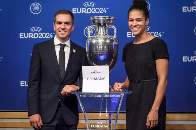 Head of the German bid Philipp Lahm, left, and former German international Celia Sasic pose with the Uefa trophy in Nyon. Picture: AFP/Getty Images