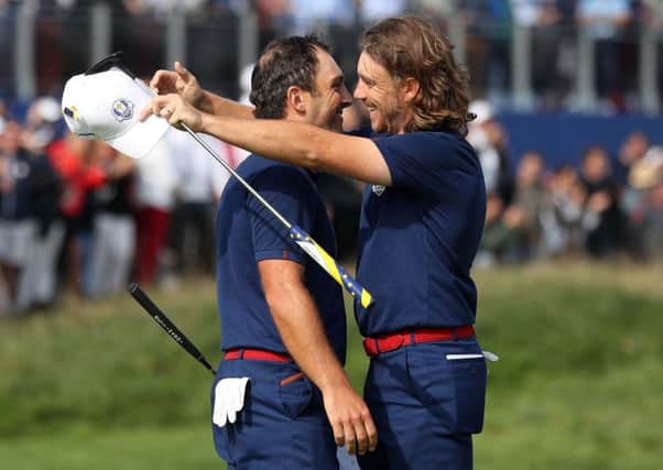 Francesco Molinari and Tommy Fleetwood embrace after securing a vital point for Europe in the opening session at Le Golf National. Picture: PA