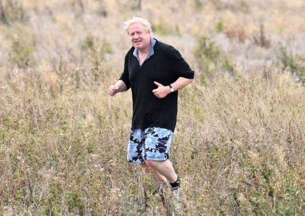 Boris Johnson jogs through a field in apparent mockery of Theresa May's confession that she once ran through a field of wheat (Picture: Leon Neal/Getty Images)