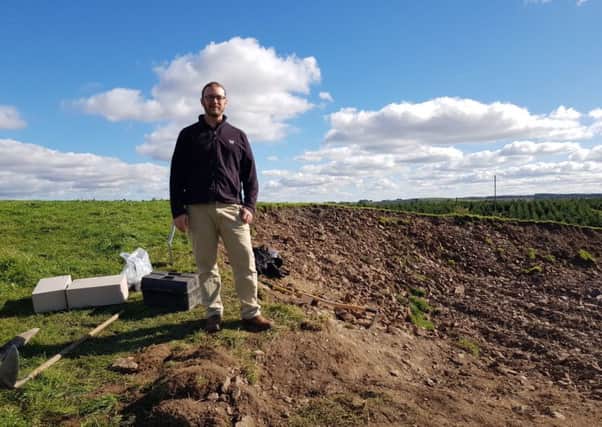 Scottish Borders Council archaeologist, Dr Chris Bowles, with some of the boxed remains at the site in Lilliesleaf
