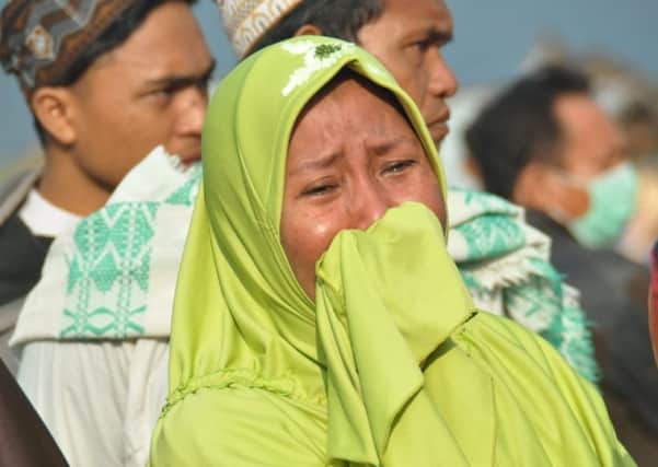 A woman cries as people look at the damages after an earthquake and a tsunami hit Palu, on Sulawesi island on September 29. Picture: AFP/Getty Images