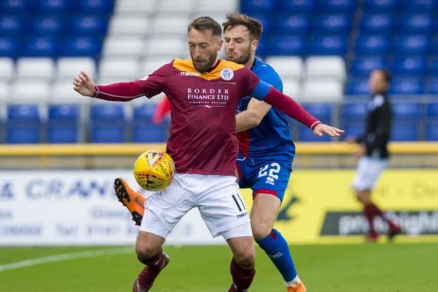Queen of the South's Stephen Dobbie is challenged by Brad Mckay. Pic: SNS/Sammy Turner