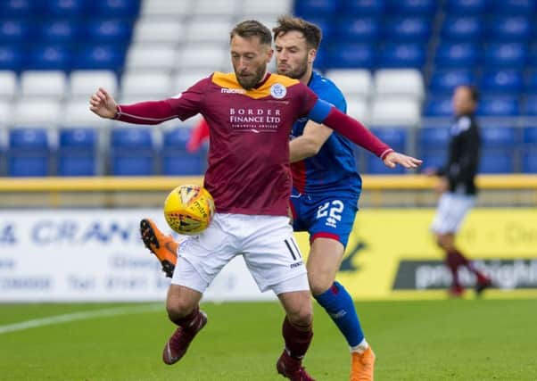 Queen of the South's Stephen Dobbie is challenged by Brad Mckay. Pic: SNS/Sammy Turner