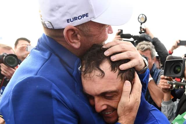 Thomas Bjorn hugs man of the moment Francesco Molinari, who became the first European player to return five points for his team. Picture: AFP/Getty