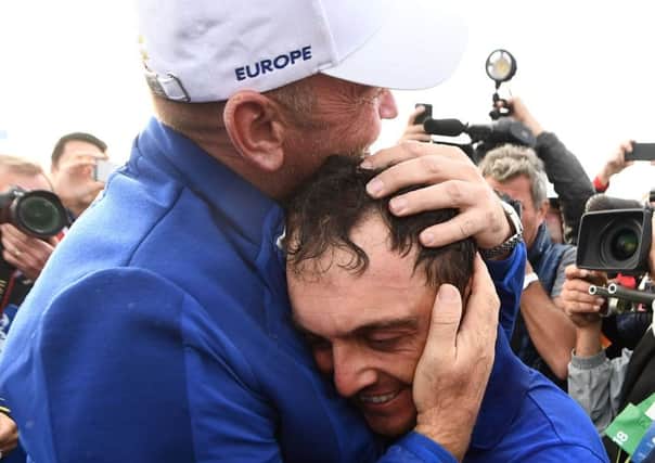 Thomas Bjorn hugs man of the moment Francesco Molinari, who became the first European player to return five points for his team. Picture: AFP/Getty
