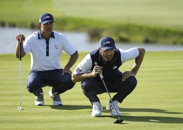 Dustin Johnson, right, and Brooks Koepka line up a putt during the foursomes at Le Golf National. Picture: Matt Dunham/AP