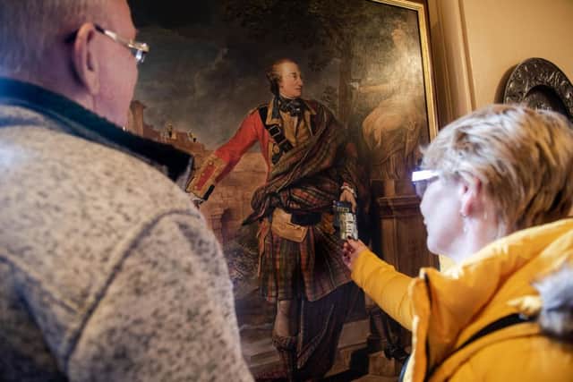 A visitor makes a donation via a replica of a  1766 painting of Colonel William Gordon at Fyvie Castle in Aberdeenshire. Picture: contributed