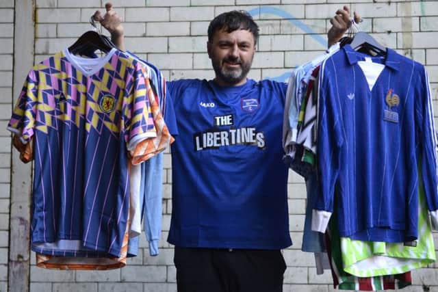 Heard is holding a Scotland 1990 Leisure shirt and France 80-82 team shirt. He is wearing Margate FC's new jersey which is sponsored by The Libertines. Picture: SWNS
