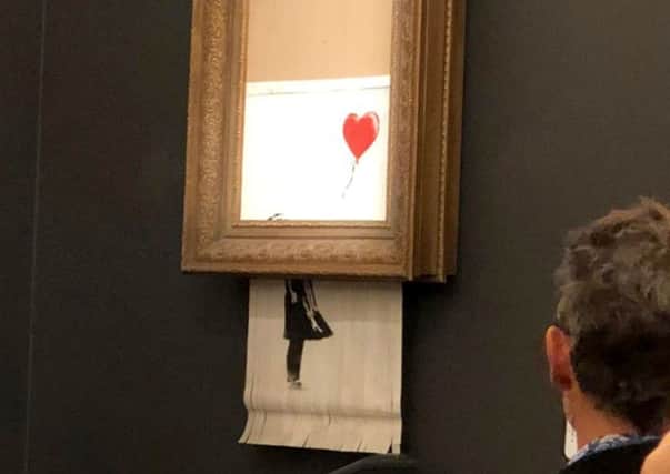 Banksy's artwork, Girl With Balloon shredded itself after being sold for more than Â£1 million at auction. Picture: PA