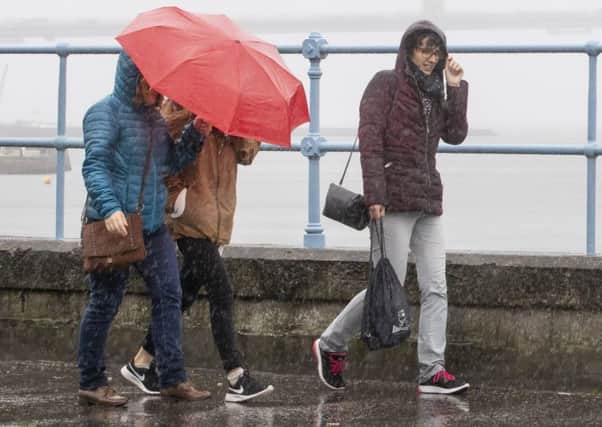 People in South Queensferry battle against the rain and wind. Picture: SWNS